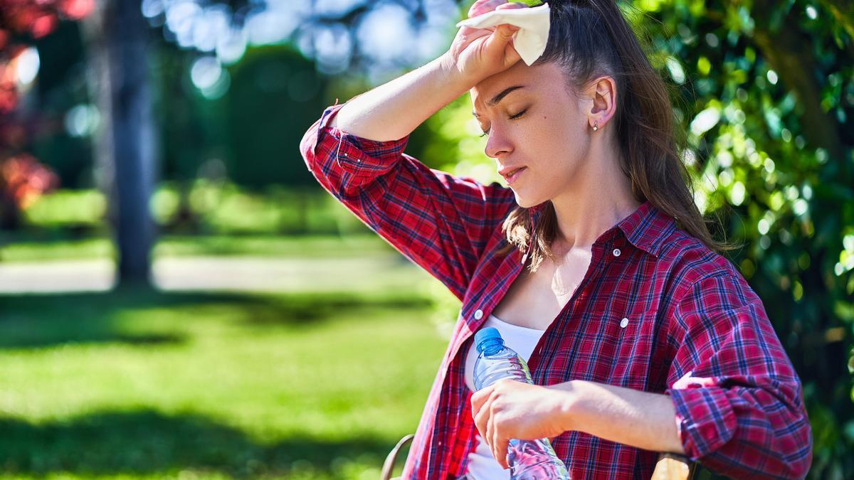 Una mujer mareada a causa del calor.