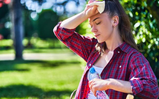 Una mujer mareada a causa del calor.
