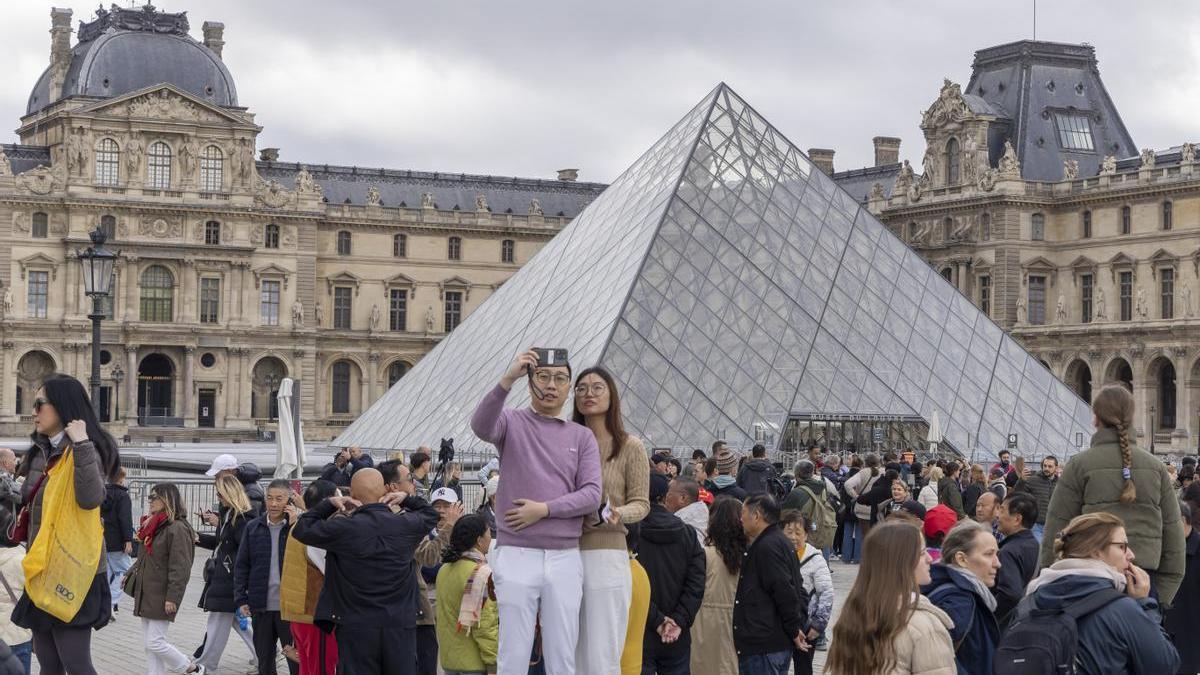 Visitantes ante el Museo del Louvre.