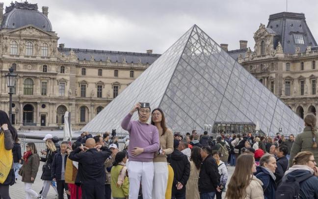 Visitantes ante el Museo del Louvre.