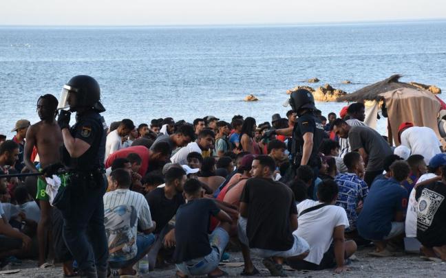 Cientos de personas migrantes reciben atención sanitaria de profesionales del INGESA y voluntarios de Cruz Roja, en la playa del Trampolín de Ceuta.