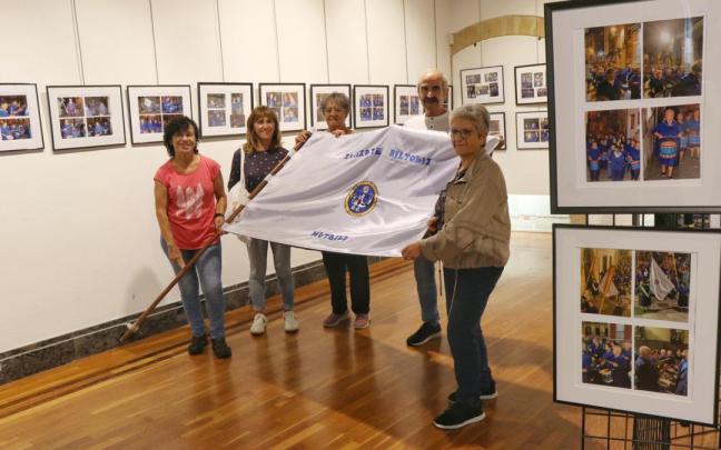 Miembros de Anaiarte, con la bandera de la asocación, en la muestra fotográfica que recoge los 25 años de la tamborrada.