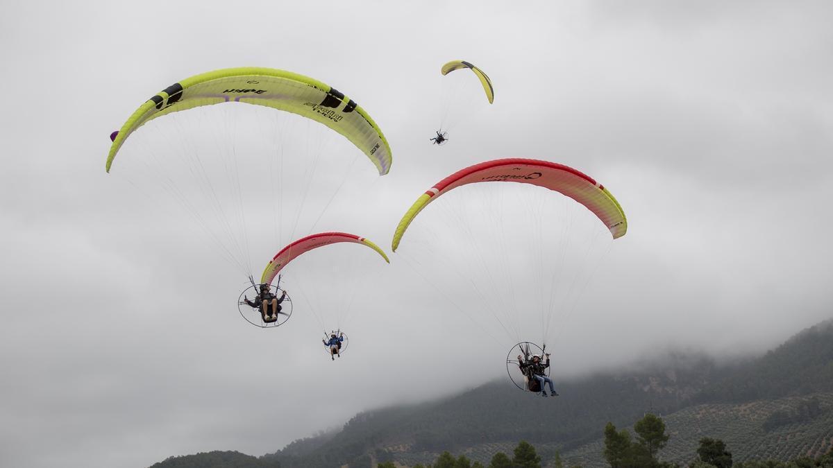 Varias personas montando en parapente.