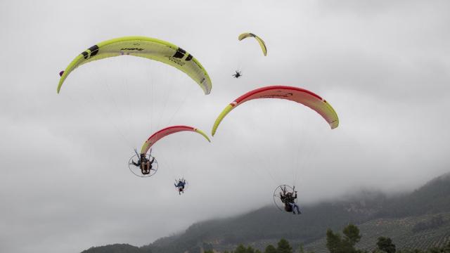 Varias personas montando en parapente.