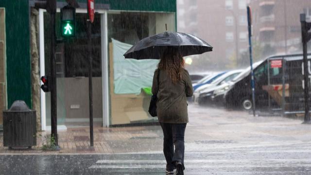 Una mujer camina bajo la lluvia. / Josu Chavarri Una mujer camina bajo la lluvia.