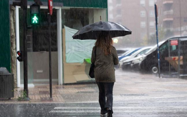 Una mujer camina bajo la lluvia. / Josu Chavarri Una mujer camina bajo la lluvia.