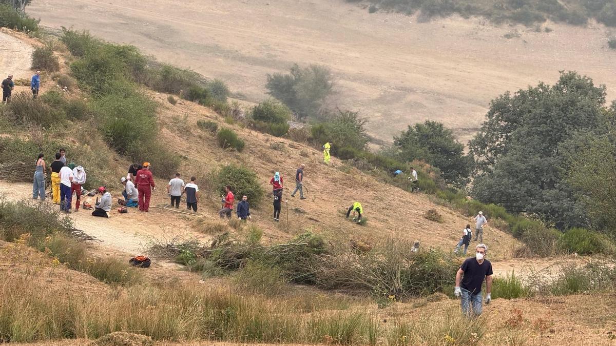 Unos 200 vecinos de Riaño se organizaron y subieron ayer a la colina para tratar de crear un cortafuegos.