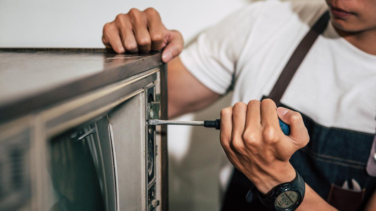 Una persona arreglando un electrodoméstico, en una imagen de archivo.