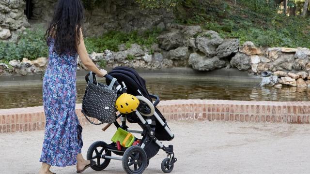 Una persona pasea con un carrito de bebé.