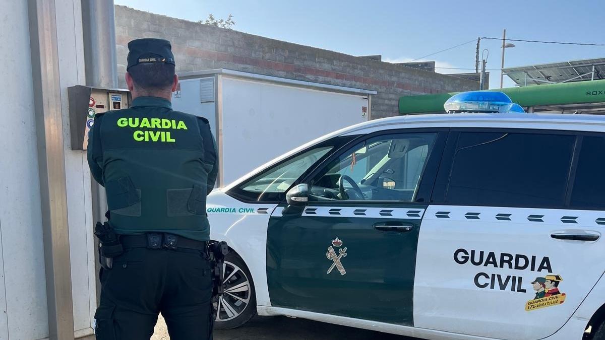 Un agente de la Guardia Civil junto a su vehículo.