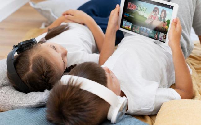 Dos niños juegan con la tablet en su hogar