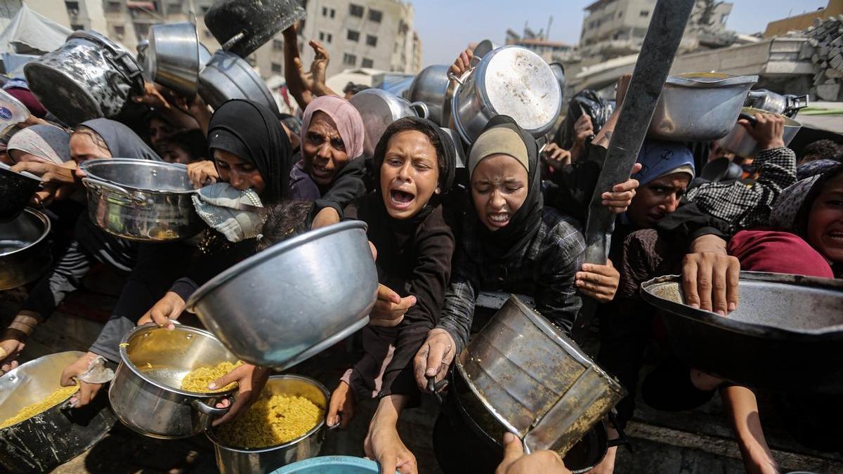 Mujeres palestinas desplazadas en Gaza esperan piden alimentos en una foto de archivo.