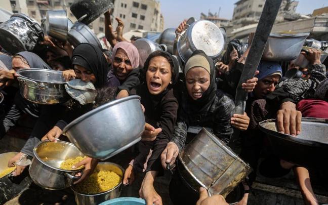 Mujeres palestinas desplazadas en Gaza esperan piden alimentos en una foto de archivo.