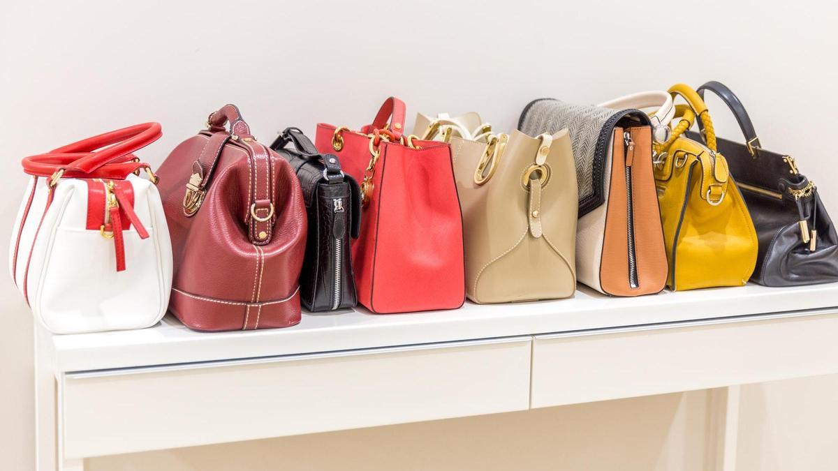 Bolsos expuestos sobre una mesa en una tienda.