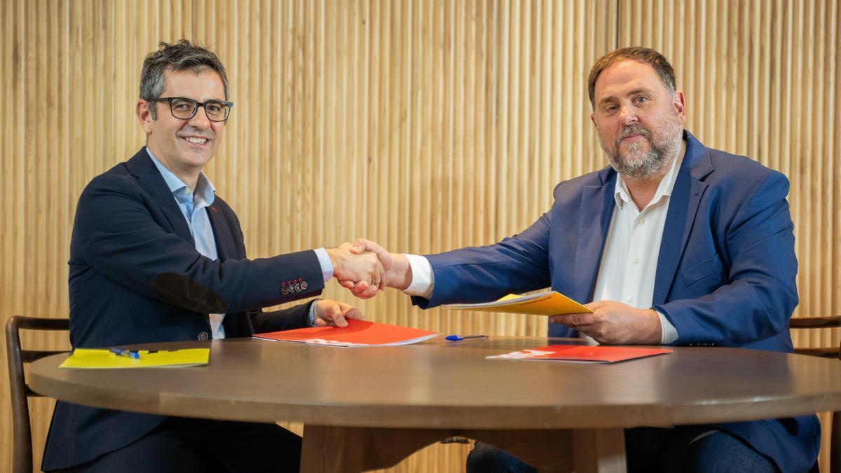 Félix Bolaños y Oriol Junqueras se dan la mano tras sellar el acuerdo para la investidura de Sánchez.