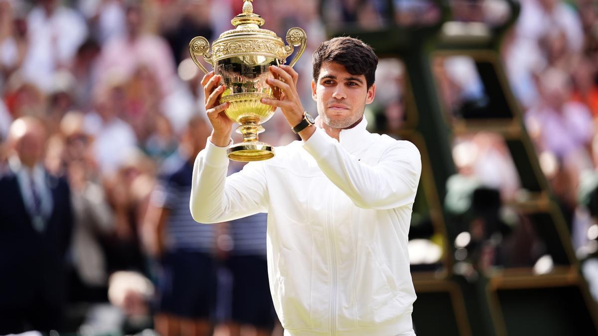 Carlos Alcaraz posando con su título de Wimbledon en 2024.
