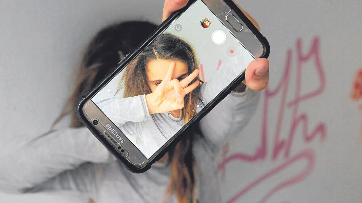 Una niña se hace un selfi con su teléfono móvil mientras los expertos piden que se racione la cantidad y los momentos del uso del mismo. | FOTO: OSKAR M. BERNAL