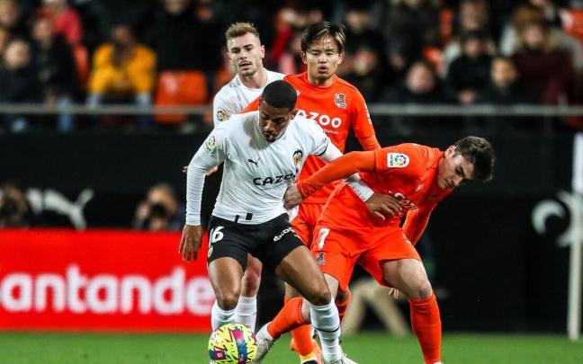 Samu Lino, del Valencia, se faja de Barrenetxea ante la mirada de Lato y Kubo.