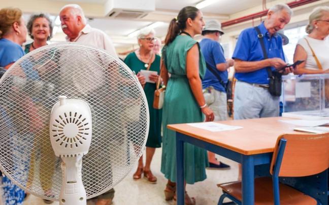 Un ventilador en una mesa electoral donde los ciudadanos ha ido a ejercer su derecho a voto durante las elecciones generales.