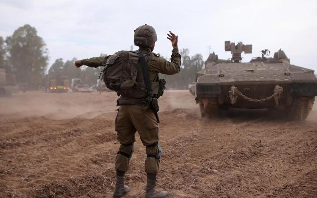 Un soldado israelí dirige el avance de un tanque.