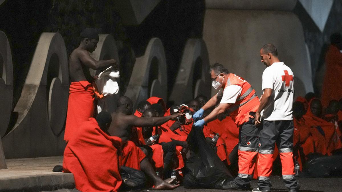 Miembros de Cruz Roja Española junto a varios migrantes a su llegada a la isla de El Hierro