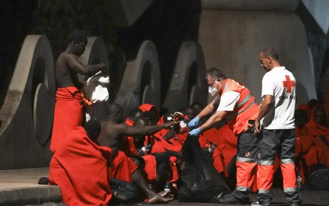 Miembros de Cruz Roja Española junto a varios migrantes a su llegada a la isla de El Hierro
