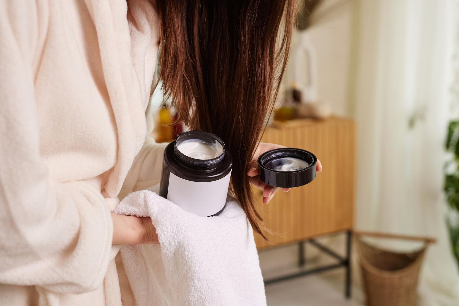 Mujer aplica una mascarilla en el cabello.