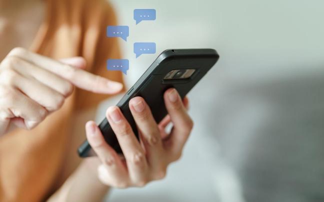 Una mujer chatea con su teléfono móvil.