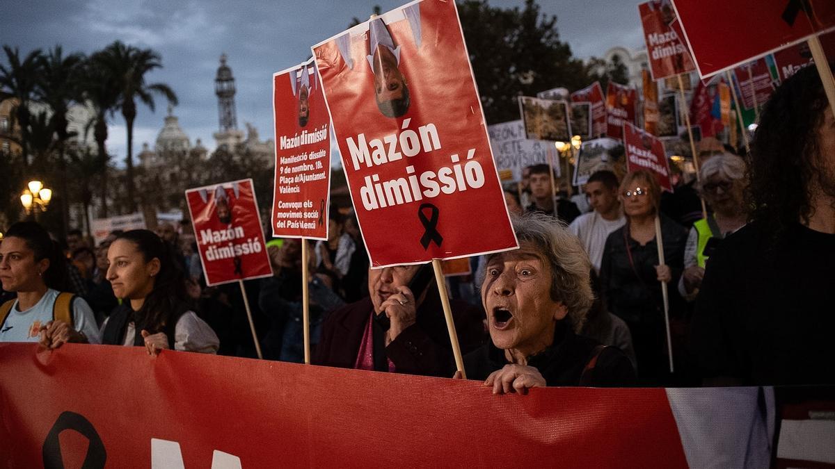 Una mujer un cartel durante una manifestación que recorre las calles de Valencia para exigir la dimisión del presidente de la Generalitat valenciana.