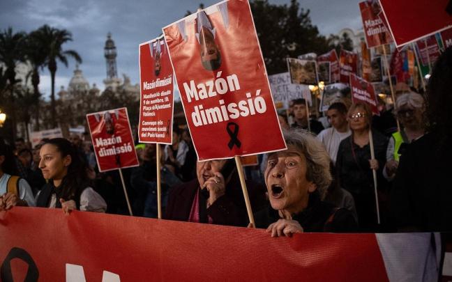 Una mujer un cartel durante una manifestación que recorre las calles de Valencia para exigir la dimisión del presidente de la Generalitat valenciana.