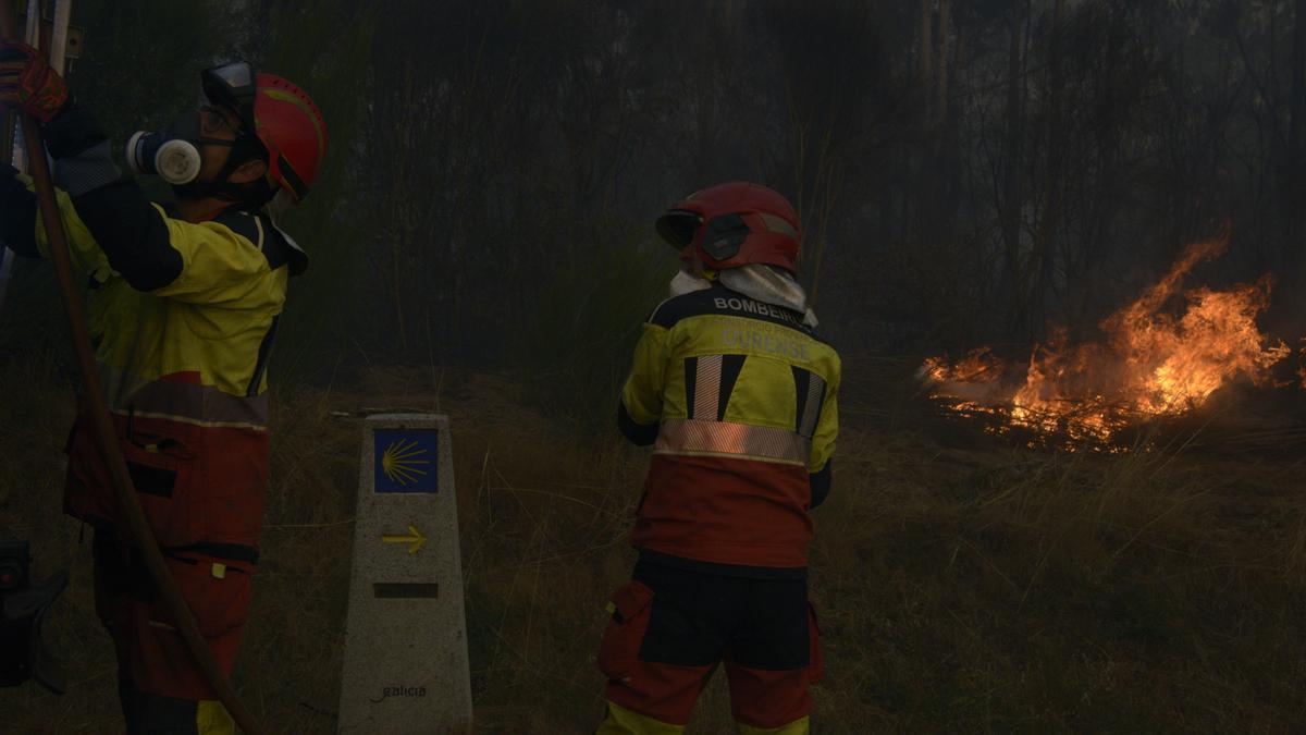Dos bomberos durante las labores de extinción de un incendio forestal.