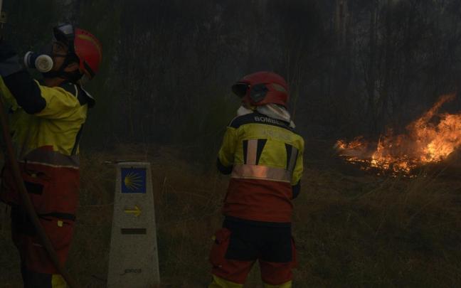 Dos bomberos durante las labores de extinción de un incendio forestal.