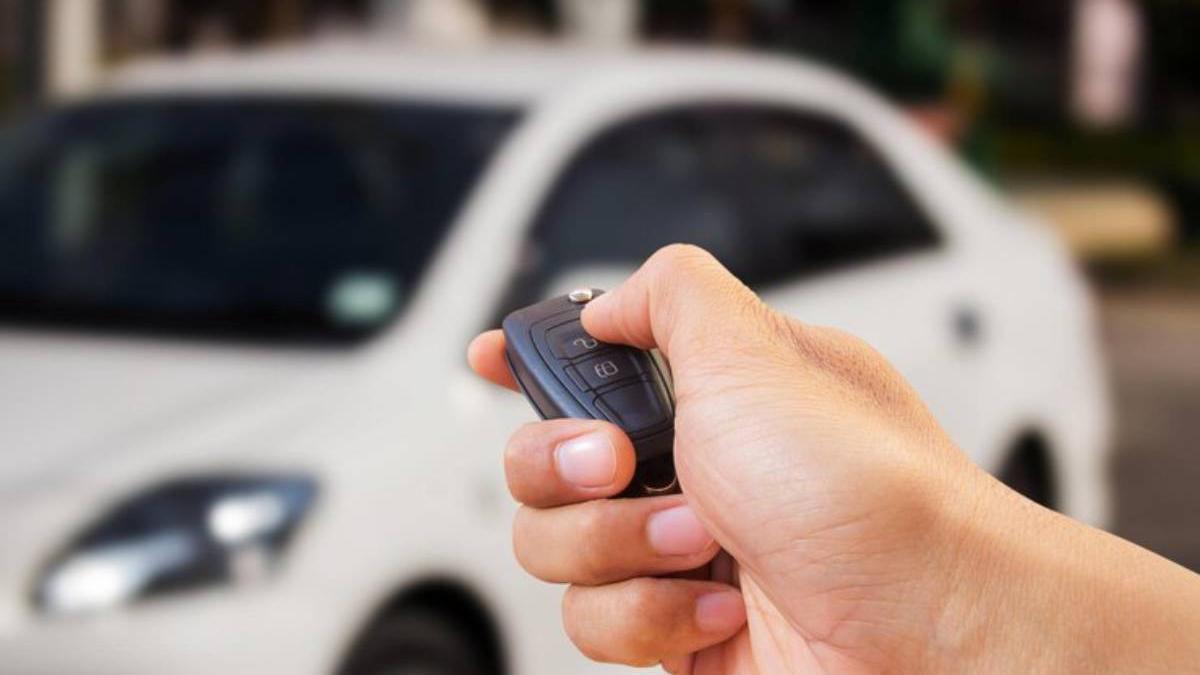 Manos de un hombre abriendo el coche con ayuda del mando