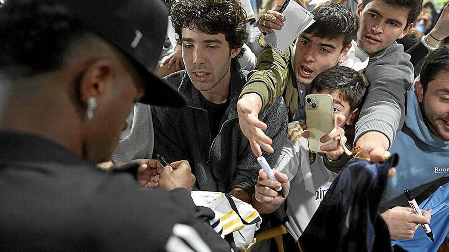 Vinicus atiende a varios aficionados que esperaban la llegda del equipo este viernes en el aeropuerto de Noáin.