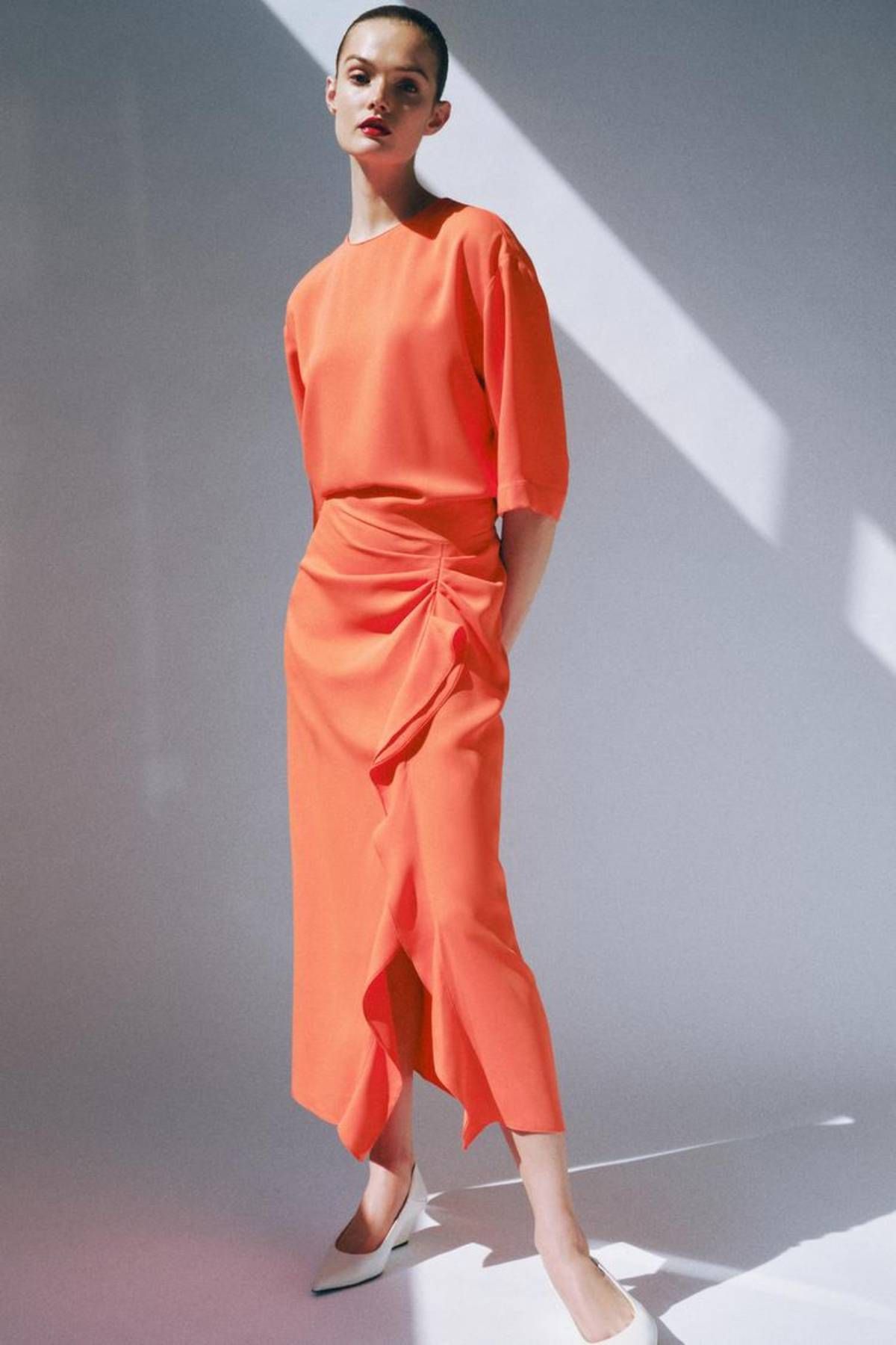 Vestido midi drapeado naranja por 39,95 euros.