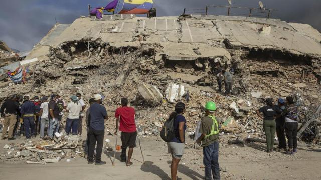 Personas observan edificios destruidos por terremotos, en Caraballeda (Venezuela).