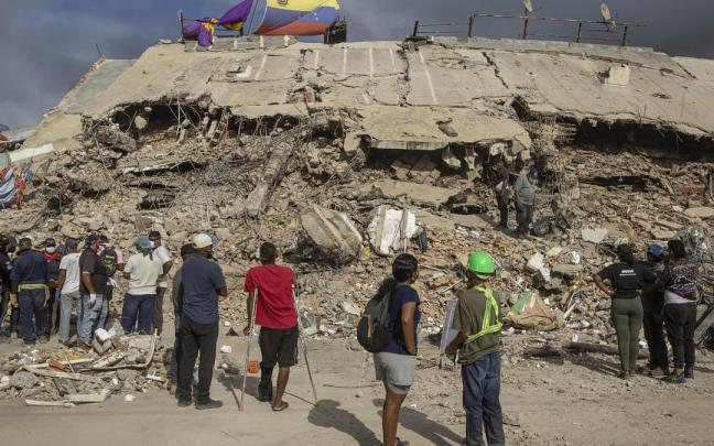 Personas observan edificios destruidos por terremotos, en Caraballeda (Venezuela).