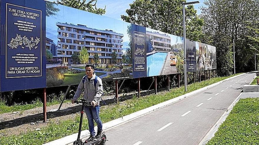 Un hombre circula en patinete junto a los terrenos donde nacerá el nuevo Ciudad Jardín.