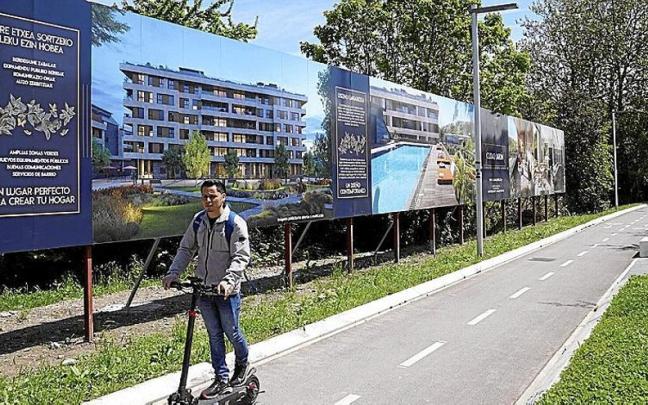 Un hombre circula en patinete junto a los terrenos donde nacerá el nuevo Ciudad Jardín.