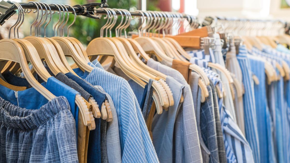 Prendas de ropa colgadas en el perchero de una tienda.