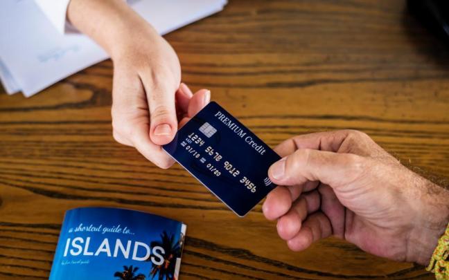 Una persona paga el servicio del hotel con la tarjeta de crédito.