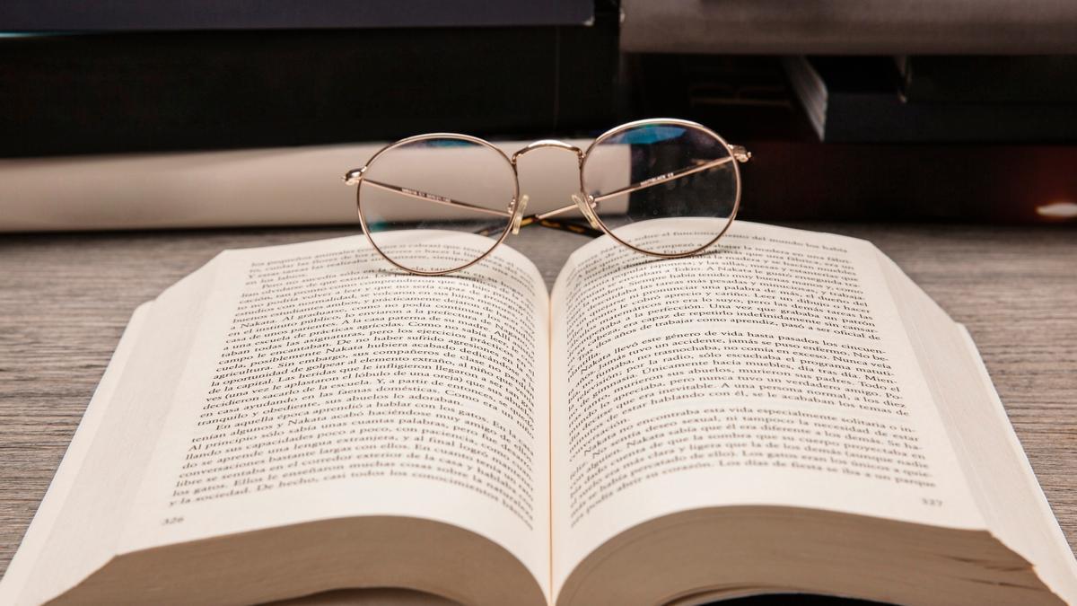 Gafas apoyadas sobre las páginas de un libro.