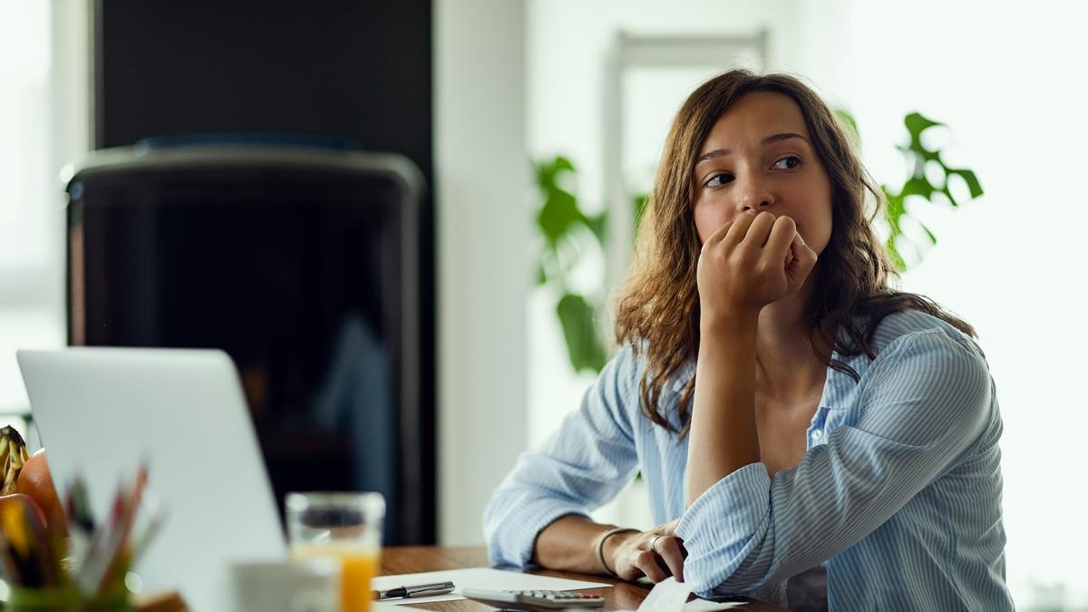 Chica pensativa en su puesto de trabajo.