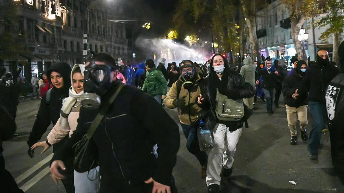 Los protestantes huyen de los cañones de agua utilizados por la policía en Tiflis.