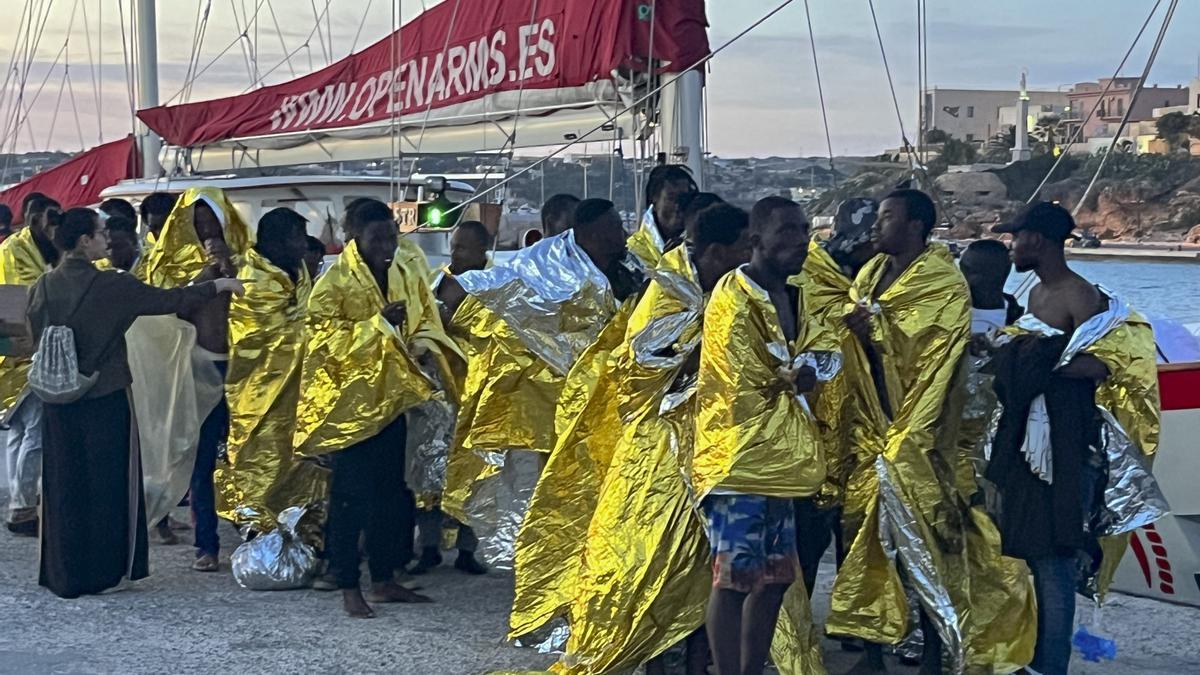 Varios migrantes rescatados en el Mediterráneo central son recibidos en el puerto italiano de Lampedusa.