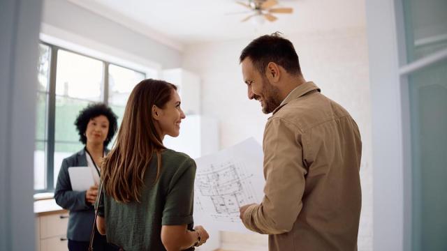 Una pareja revisa los planos de la vivienda que desea adquirir.