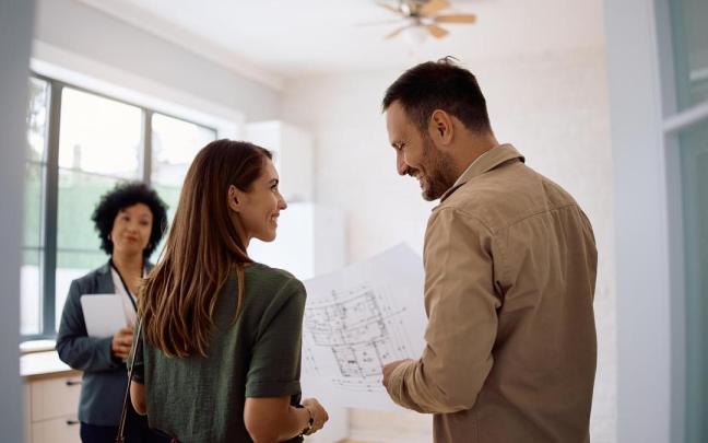 Una pareja revisa los planos de la vivienda que desea adquirir.