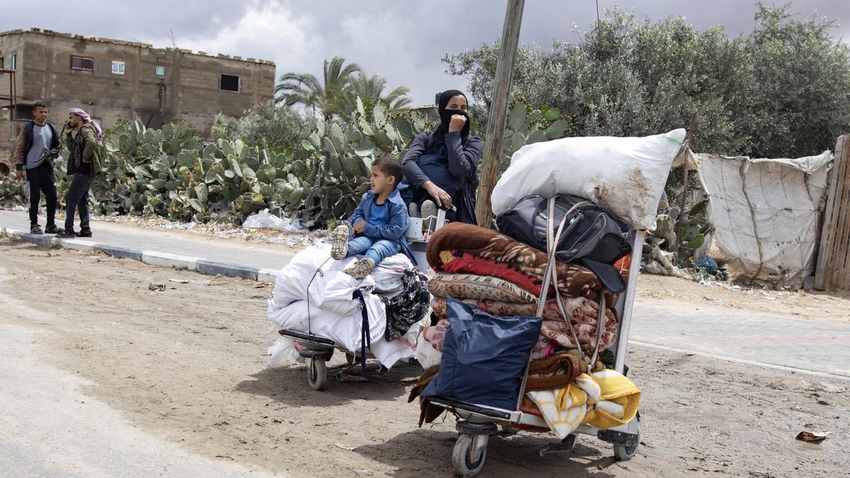 Una mujer junto a su hijo abandona las calles de Rafah tras la orden de evacuación israelí.
