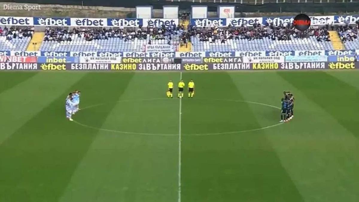 Los jugadores de ambos equipos, guardando el minuto de silencio.