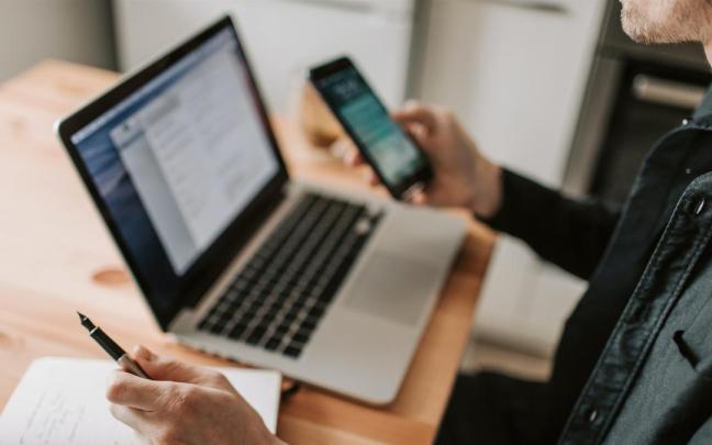 Un hombre utilizando un ordenador y un teléfono móvil. / EP Un hombre utilizando un ordenador y un teléfono móvil.